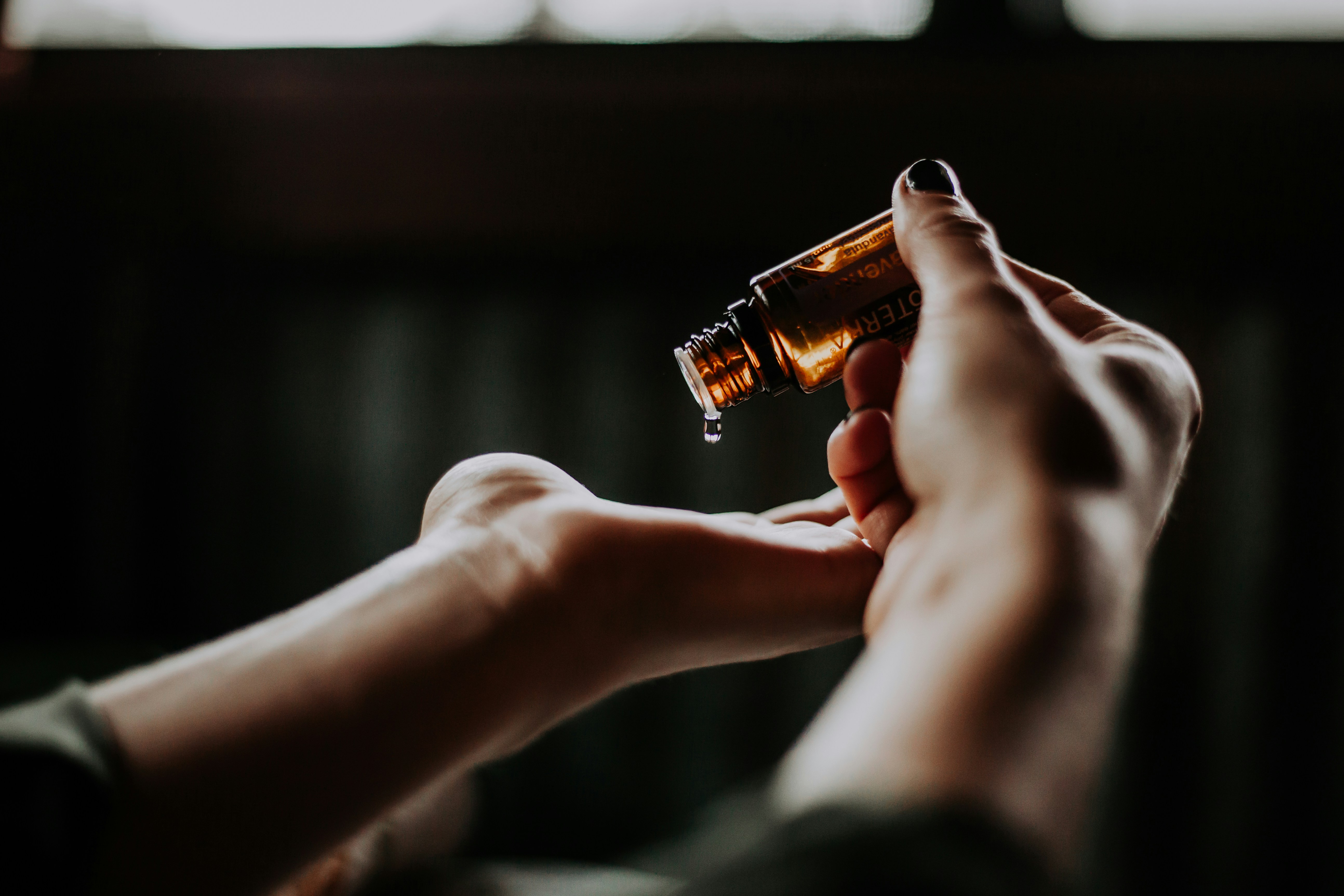 Essential oil being poured into a hand