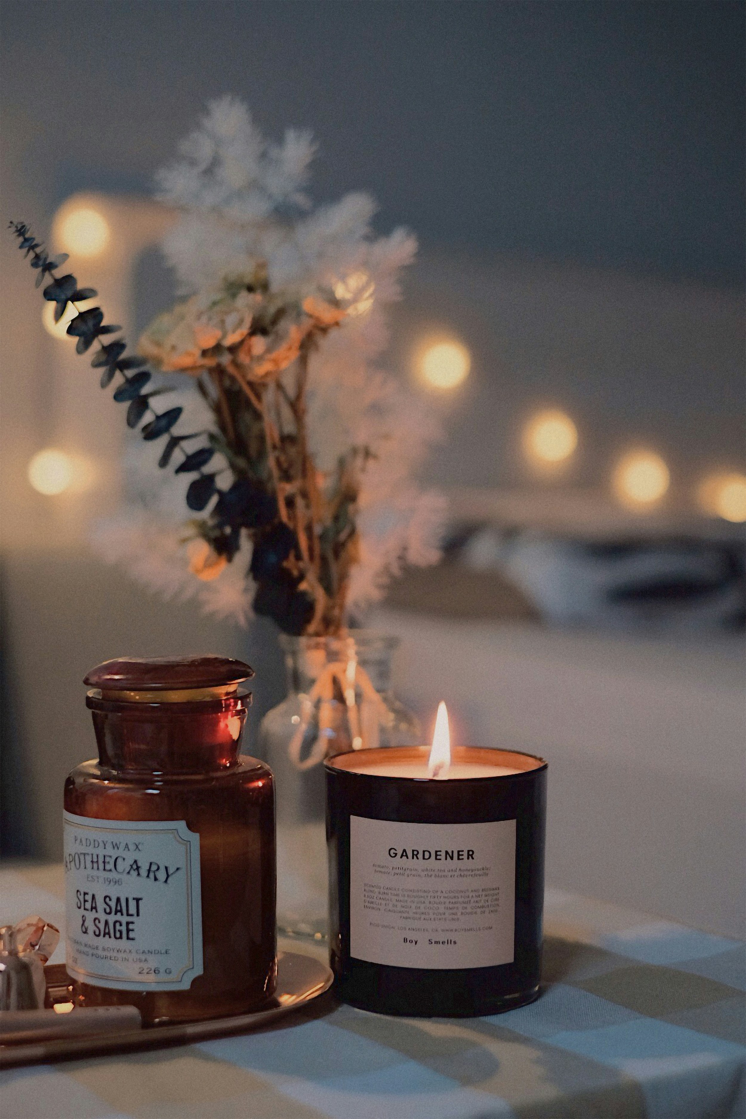 Lit candle beside a vase